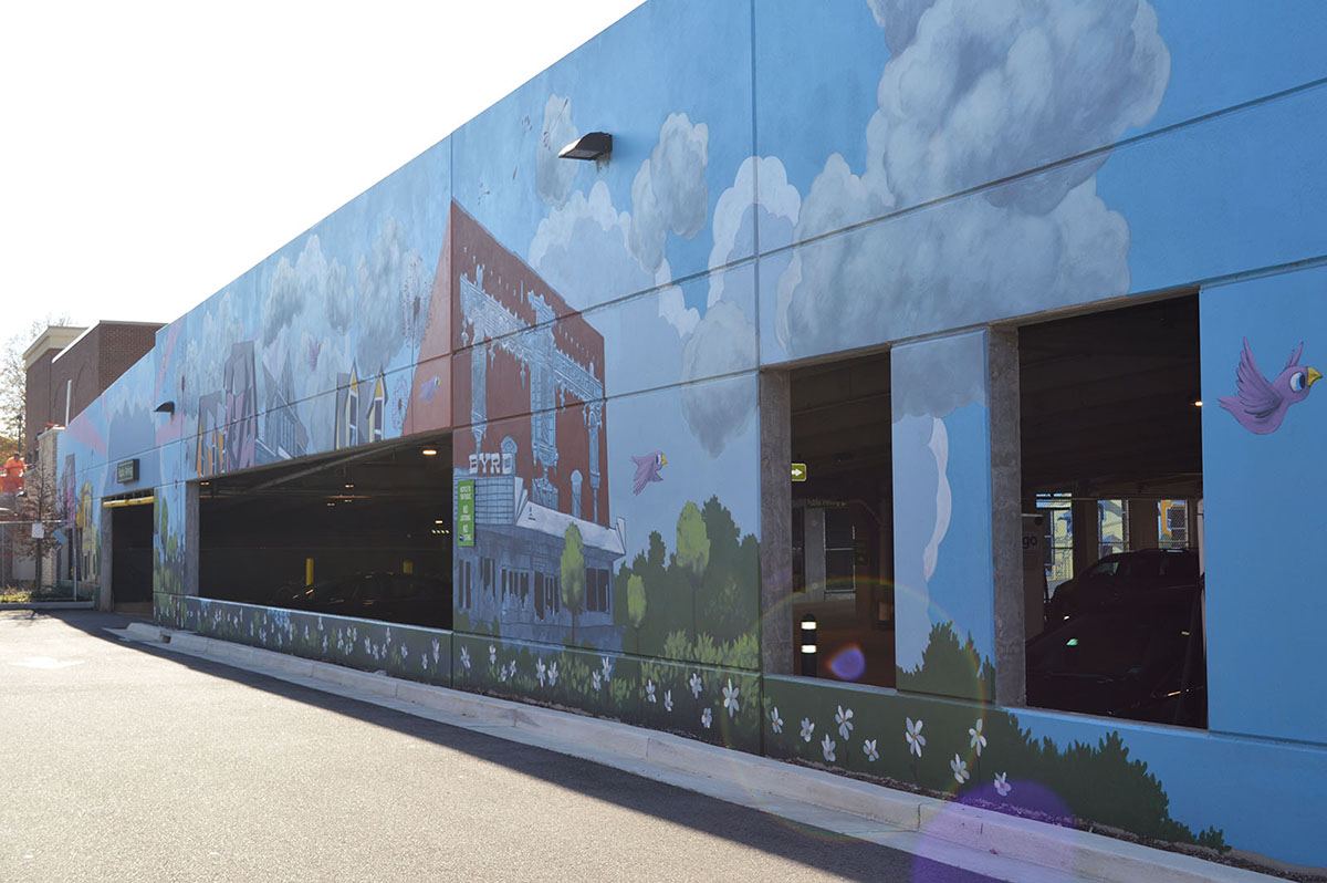 Angled view of Carytown Exchange shopping center exterior parking garage mural